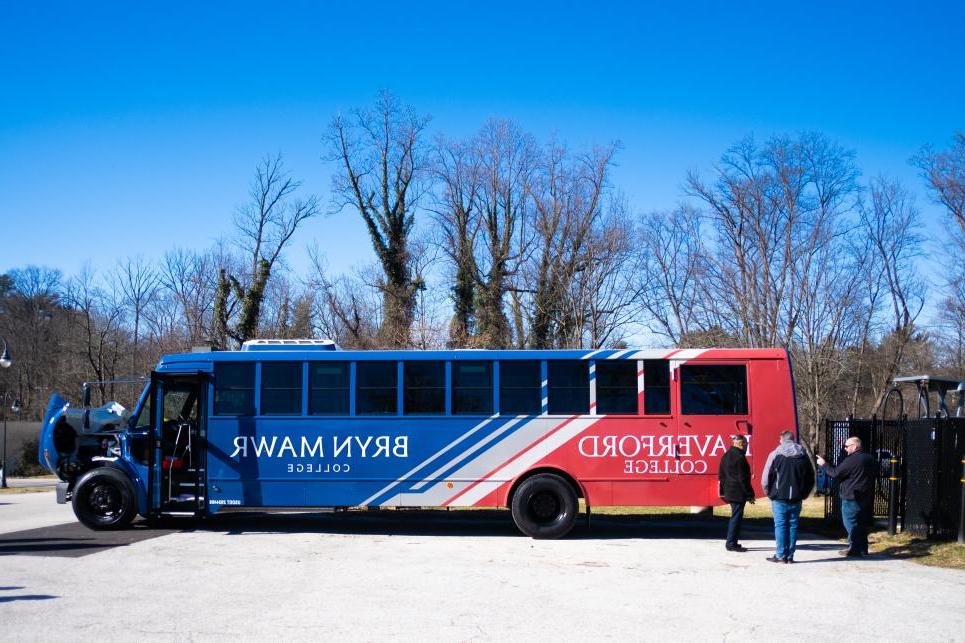 A side view of the electric bus wrapped in blue and red for Bryn Mawr and Haverford.
