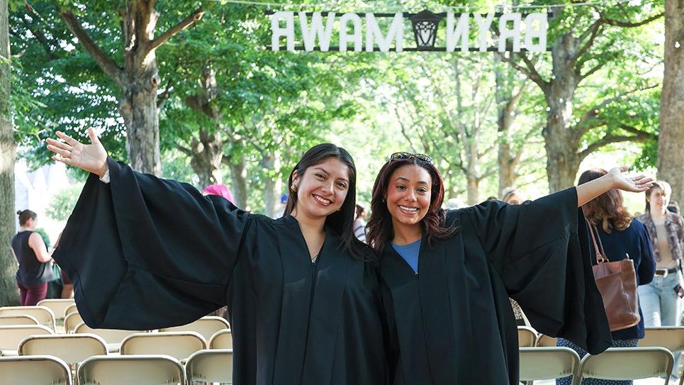 Convocation 2024 two students in front of senior row and Bryn Mawr sign