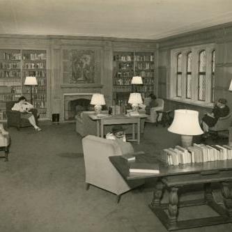 Wood paneled room with students reading in chairs